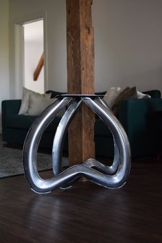 a metal object sitting on top of a wooden floor next to a blue couch in a living room