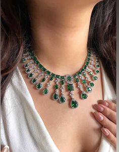 Add a touch of glamour and sophistication with this high quality necklace set in beautiful  emerald green stones. The stones in this set bling and look close to the real thing. This set is sure to make heads turn!  It features an adjustable necklace and a pair of earrings. It can be paired perfectly with both ethnic and western outfits.  In case of any queries, please feel free to reach out. Happy shopping! Item includes Necklace, earrings and maangtika Measurements:  Necklace length: 16 inches (adjustable length with silver colour metal chain) Earrings length: 2" Each earring weighs: 12 gms Dazzling Green Bridal Necklace For Anniversary, Green Diamond Bridal Necklace With Jewels, Green Cubic Zirconia Bridal Necklace With Sparkling Stones, Green Crystal Emerald Necklace For Wedding, Green Crystal Necklace For Wedding, Green Cubic Zirconia Bridal Necklace Hand Set, Green Hand-set Cubic Zirconia Bridal Necklace, Dazzling Green Hand Set Bridal Necklace, Dazzling Green Bridal Necklace With Hand Set