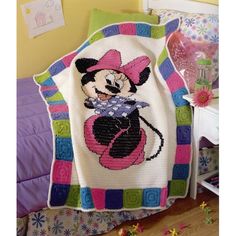 a crocheted blanket with a minnie mouse on it in a child's bedroom