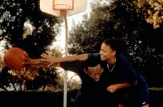 two women playing basketball on an outdoor court