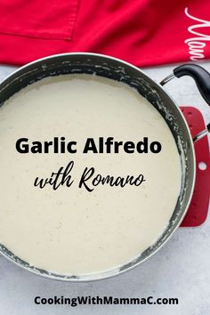 garlic alfredo with romano in a pan on a table next to a red towel