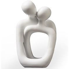 a white sculpture with two people hugging each other