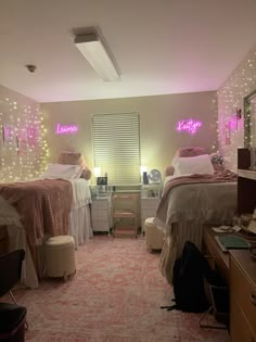 two beds in a room with pink lights on the walls and carpeted flooring