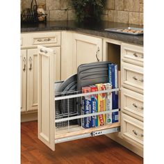 a kitchen with white cabinets and drawers filled with books, binders and folders