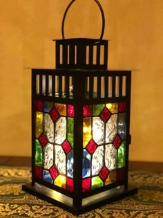 a stained glass lantern sitting on top of a rug