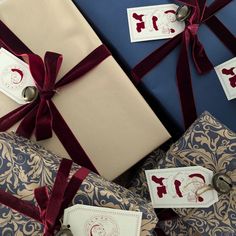 presents wrapped in brown and blue paper with red ribbon tied around them, sitting next to each other