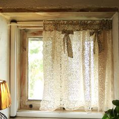 a window with curtains and a lamp in front of it