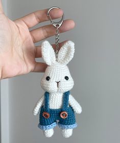 a crocheted bunny keychain hanging from a persons hand