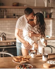 a man and woman kissing in the kitchen