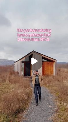 a woman walking down a dirt road next to a small building with a sign that says the pretesting luxury getaway just 2 hours from nyc