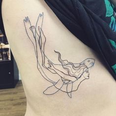 a woman's back with a line work tattoo on it