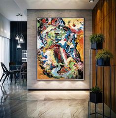 an abstract painting hangs on the wall in a modern living room with black chairs and tables