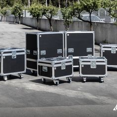 four black cases sitting on top of each other in the middle of a parking lot