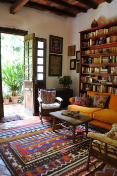 a living room filled with lots of furniture and bookshelves next to a doorway