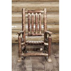 a wooden rocking chair sitting in front of a log wall