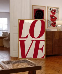 there is a large red love sign on the wall next to a wooden table and chair