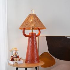 a table with a lamp, figurine and other items on it