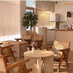 a room filled with lots of wooden chairs next to a table and potted plant