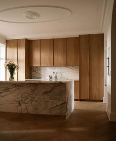 a kitchen with marble counter tops and wooden cabinets