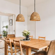 a dining room table with chairs and a vase on it