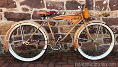 a wooden bicycle parked against a brick wall