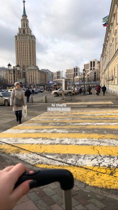 a person is walking down the street with their hand on an object in front of them