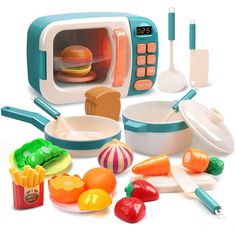 a toy microwave with food and utensils in front of it on a white background