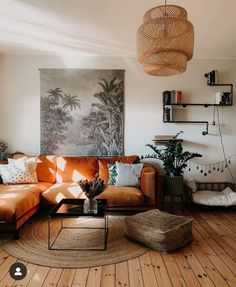 a living room filled with furniture and a painting hanging on the wall above it's headboard