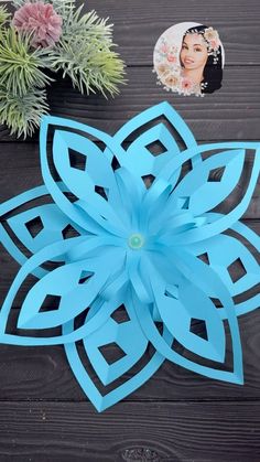 a blue paper flower sitting on top of a wooden table