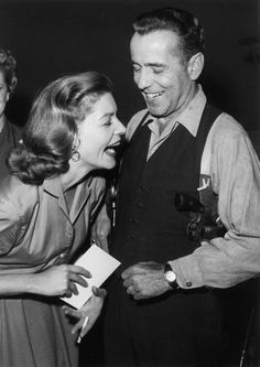 an old black and white photo of two women laughing with a man in the background