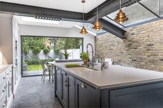 an open kitchen and dining room with brick walls