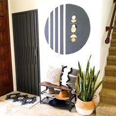 a living room with a plant and some decorations on the wall next to a door