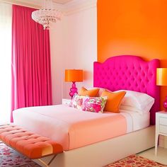 an orange and pink bedroom with a large bed