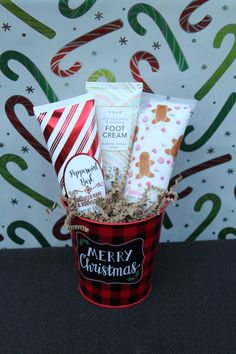 a red bucket filled with lots of different items next to a christmas wall paper background