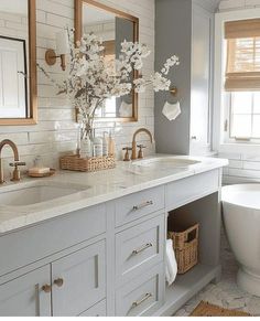 a white bathroom with two sinks and a tub