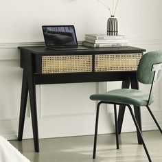 a laptop computer sitting on top of a wooden desk next to a chair and lamp