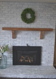 a white brick fireplace with a wreath above it