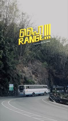 a bus driving down a curvy road next to a lush green hillside covered in trees