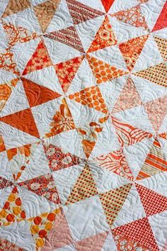 an orange and white quilt is on display