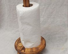 a toilet paper holder made out of wood with a roll of toilet paper in it