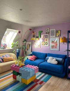 a living room filled with colorful furniture and pictures hanging on the wall above couches