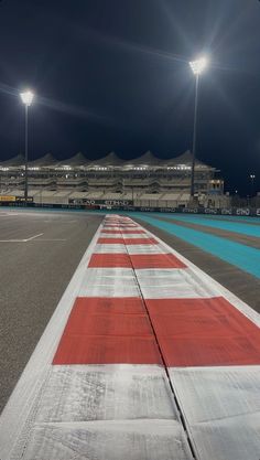 an empty race track with lights in the background