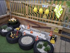 there are many different types of garden items in the yard with construction signs on the fence behind them