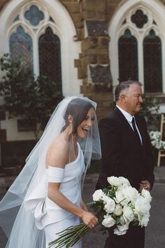 a bride and groom walking down the street