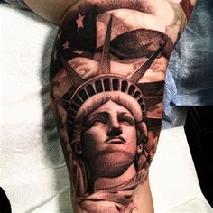 the statue of liberty tattoo is on someone's arm