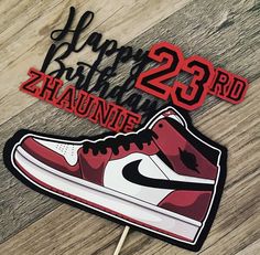 a birthday cake topper with a pair of shoes on it and the number 23