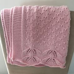 three pink knitted blankets sitting on top of a chair