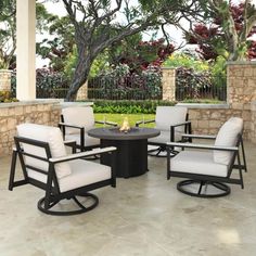 an outdoor patio with chairs, table and fire pit