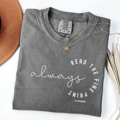 a t - shirt that says read the always inked on it next to a hat