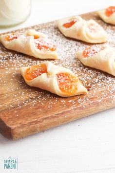 small pizzas are arranged on a cutting board with sugar sprinkled around them